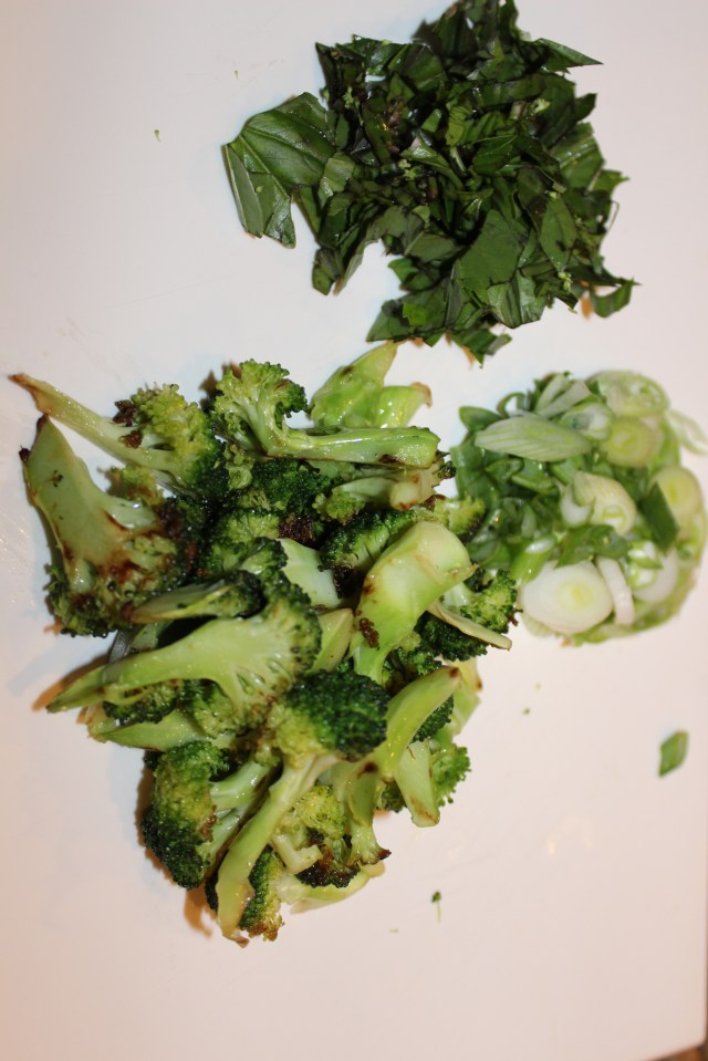 Toppings for soup: broccoli florets, ribbons of basil and sliced scallions