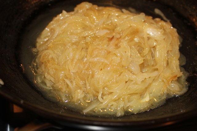 In a quarter cup of olive oil, saute sliced onions, initially on medium high heat until they come together en masse.