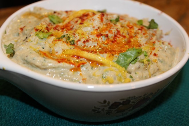 Baba ganoush is a creamy, tangy dip made with sesame seed paste (tahini) and mashed roasted eggplant, garnished with generous drizzles of olive oil and paprika.